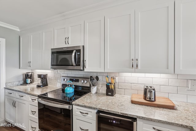 21 S Forest Beach Dr Unit 210, Hilton Head Island, SC 29928 - kitchen featuring stainless steel appliances, wine cooler, white cabinetry, ornamental molding, and decorative backsplash