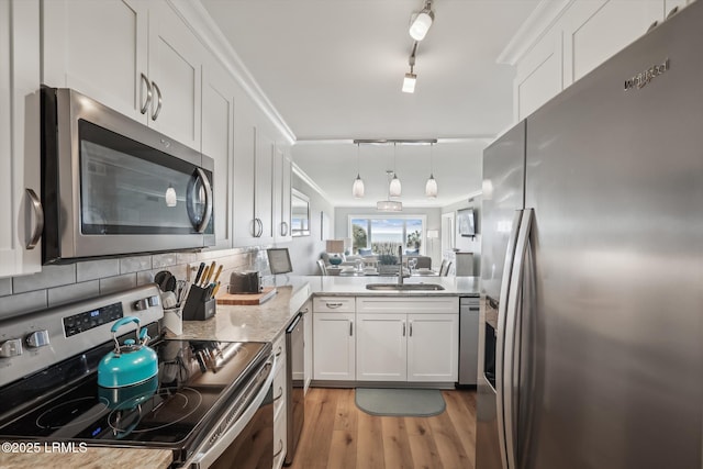 21 S Forest Beach Dr Unit 210, Hilton Head Island, SC 29928 - kitchen with stainless steel appliances, white cabinetry, light wood-style flooring, backsplash, and pendant lighting