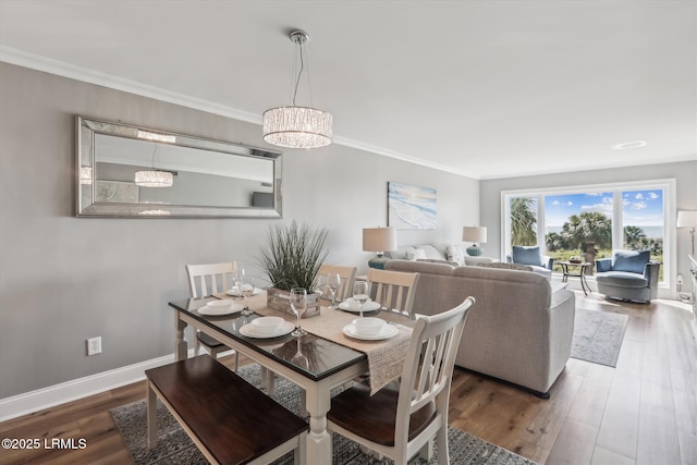 21 S Forest Beach Dr Unit 210, Hilton Head Island, SC 29928 - dining room featuring wood finished floors, crown molding, and a chandelier