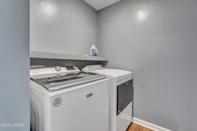 washroom with light hardwood / wood-style flooring and independent washer and dryer