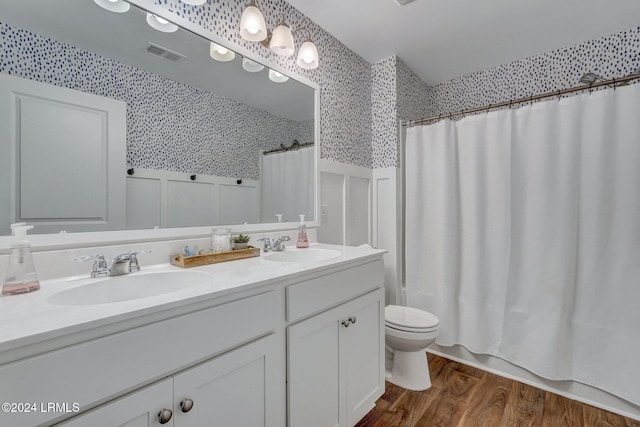 full bathroom with vanity, toilet, hardwood / wood-style floors, and shower / bath combo