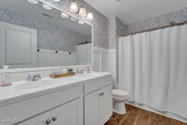 full bathroom with vanity, toilet, hardwood / wood-style floors, and shower / bath combo