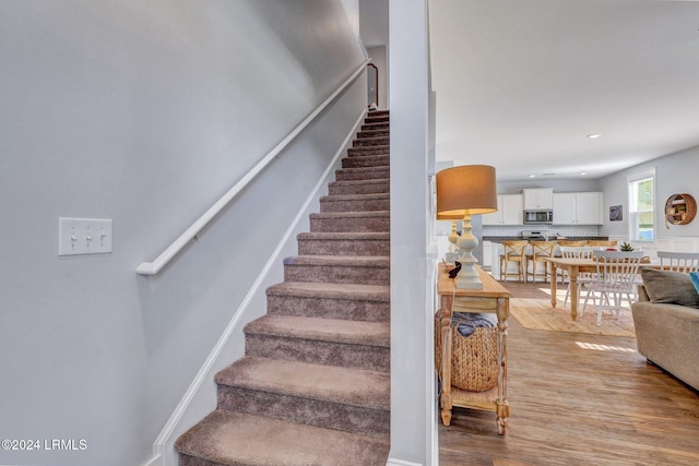 staircase with hardwood / wood-style floors