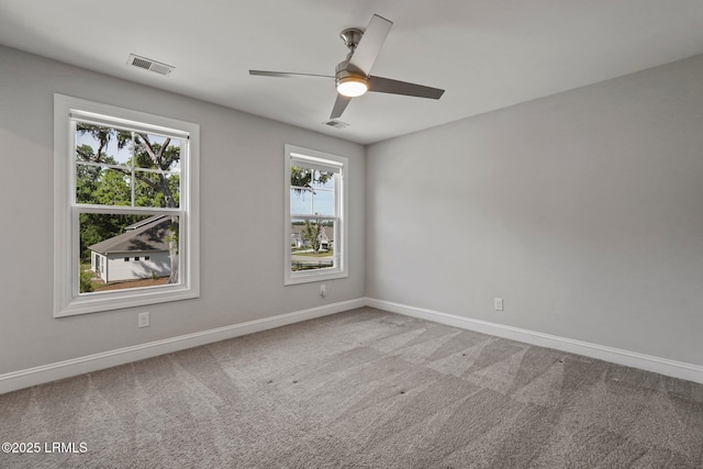 unfurnished room with visible vents, ceiling fan, carpet flooring, and baseboards