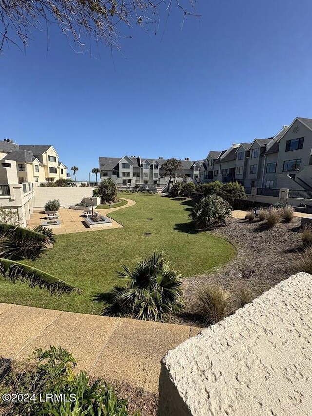 view of property's community featuring a patio and a lawn