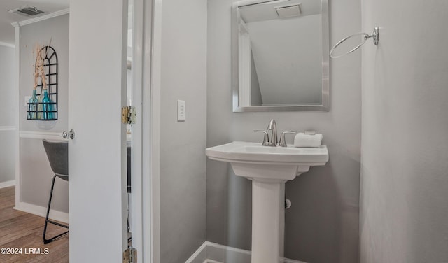 bathroom with crown molding and hardwood / wood-style flooring