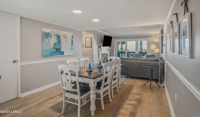 dining space with hardwood / wood-style flooring and ornamental molding