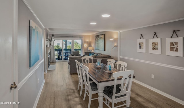 dining room with hardwood / wood-style flooring and crown molding