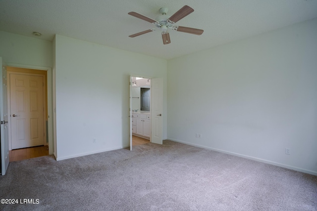 unfurnished bedroom with ensuite bathroom, light carpet, and ceiling fan