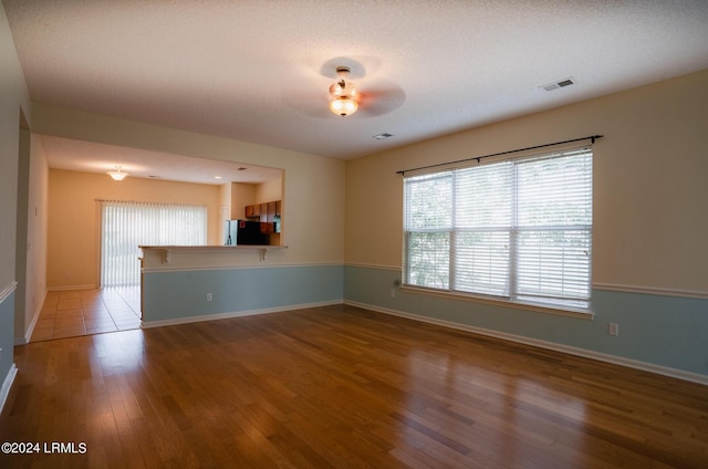 empty room with hardwood / wood-style flooring and a textured ceiling