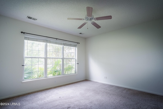 spare room featuring ceiling fan, carpet floors, and a textured ceiling