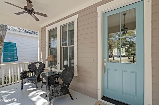 view of exterior entry featuring covered porch and ceiling fan