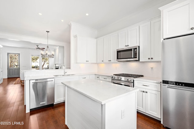 kitchen with a sink, tasteful backsplash, stainless steel appliances, white cabinets, and dark wood-style flooring