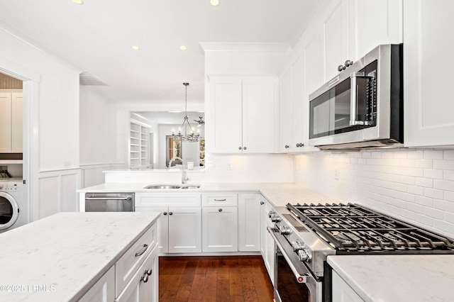 kitchen featuring a sink, light stone counters, washer / clothes dryer, and stainless steel appliances