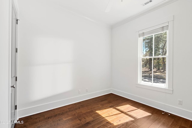 empty room featuring plenty of natural light, baseboards, visible vents, and dark wood-style flooring