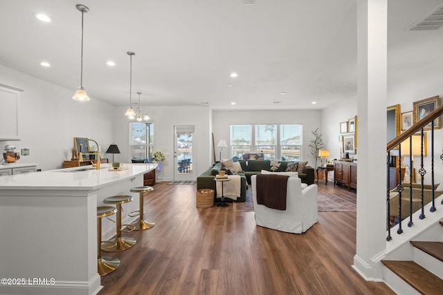 living room featuring sink, a notable chandelier, and dark hardwood / wood-style floors