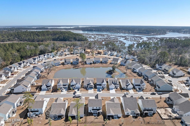 drone / aerial view with a residential view, a view of trees, and a water view