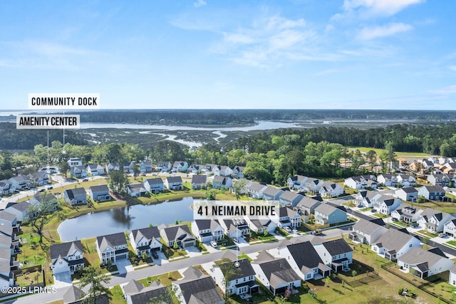 drone / aerial view with a view of trees, a residential view, and a water view