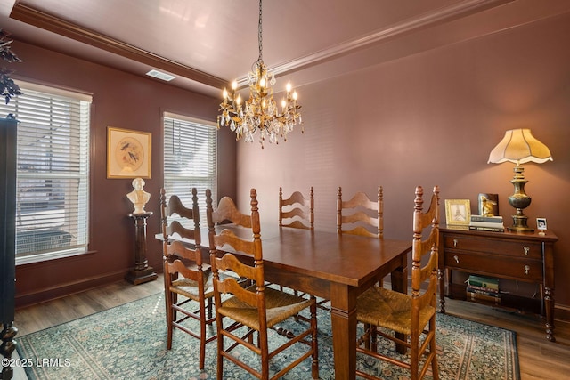 dining room featuring an inviting chandelier, hardwood / wood-style floors, and ornamental molding