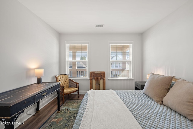 bedroom featuring wood finished floors, visible vents, and baseboards