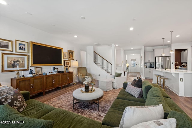 living room with stairs, recessed lighting, and light wood-style floors