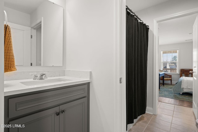 full bath with tile patterned flooring, vanity, ensuite bathroom, and baseboards