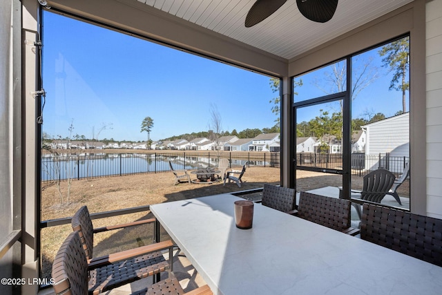 view of patio with a ceiling fan, outdoor dining area, a fenced backyard, and a water view