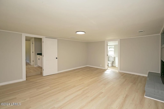 unfurnished living room with crown molding and light hardwood / wood-style floors