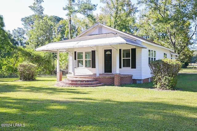 view of front of home featuring covered porch and a front lawn