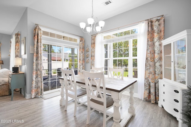 dining area featuring a notable chandelier and light wood-type flooring