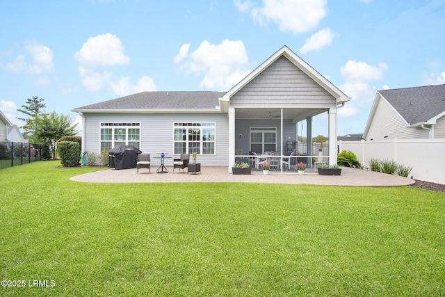 rear view of house with a patio area, a sunroom, ceiling fan, and a lawn