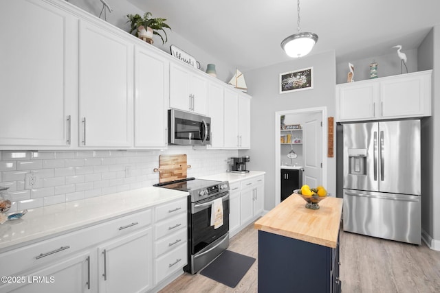 kitchen with light wood-style flooring, butcher block countertops, decorative backsplash, white cabinets, and appliances with stainless steel finishes