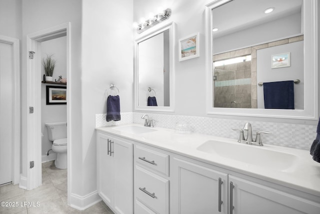 bathroom featuring a sink, tasteful backsplash, toilet, and a stall shower