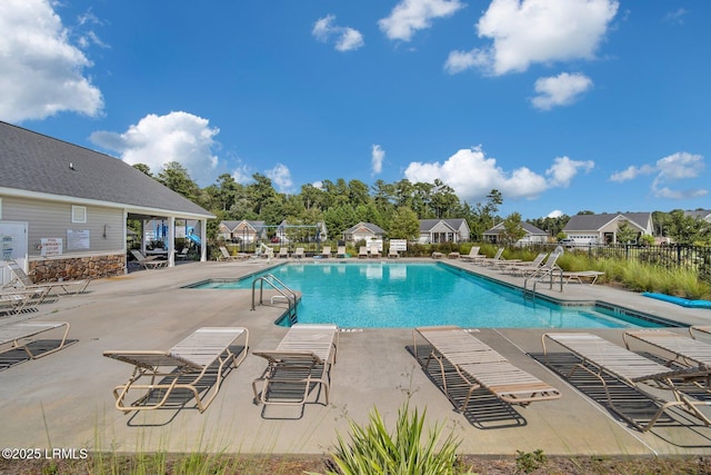 community pool featuring a patio, a residential view, and fence