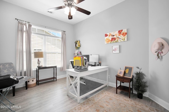 office with ceiling fan, visible vents, baseboards, and wood finished floors