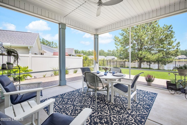 sunroom / solarium featuring a water view and ceiling fan