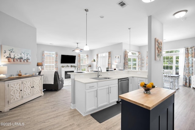 kitchen with visible vents, light wood-type flooring, white cabinetry, wood counters, and a sink