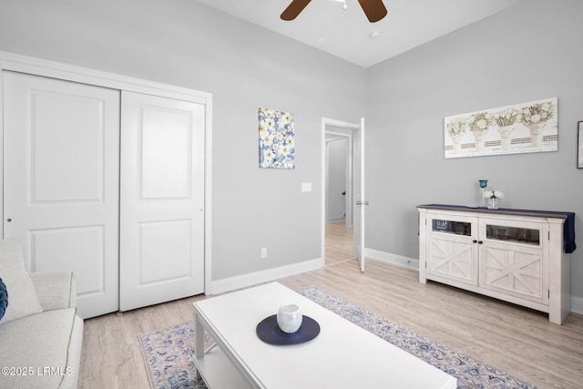 interior space with light wood-type flooring, a closet, baseboards, and a ceiling fan