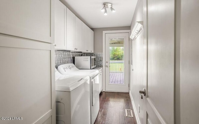 washroom with cabinets, separate washer and dryer, and dark wood-type flooring