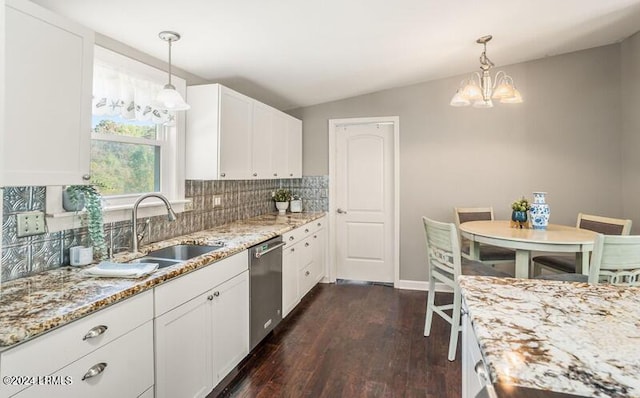 kitchen featuring stainless steel dishwasher, sink, pendant lighting, and white cabinets