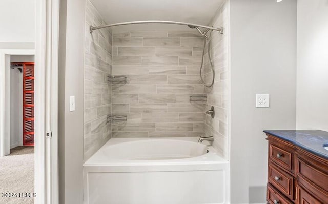 bathroom featuring tiled shower / bath and vanity