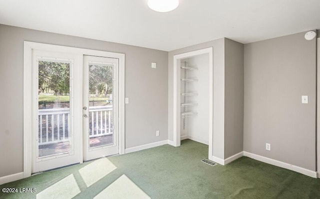 unfurnished bedroom featuring dark colored carpet, a closet, and access to outside