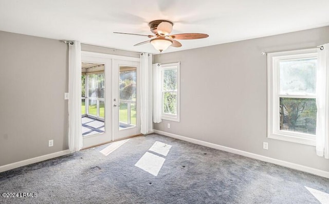 carpeted spare room with ceiling fan and french doors