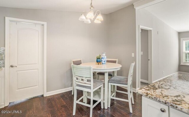 dining room with lofted ceiling, dark hardwood / wood-style floors, and an inviting chandelier