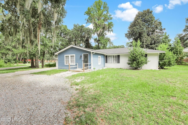 single story home featuring brick siding, driveway, and a front yard