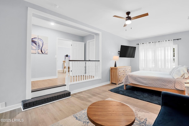 bedroom featuring ceiling fan, wood finished floors, and baseboards
