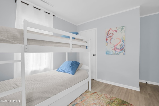 bedroom featuring visible vents, wood finished floors, and baseboards