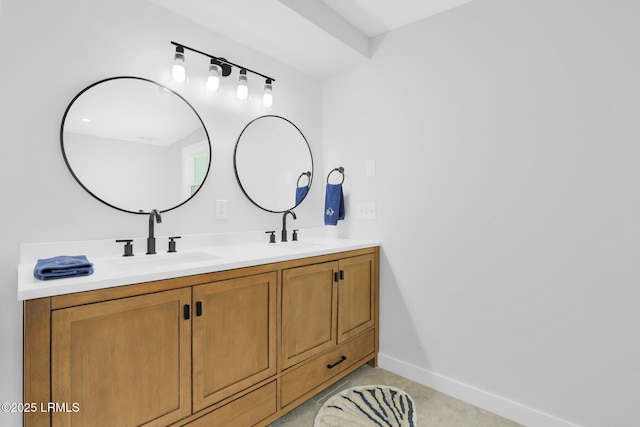 bathroom featuring double vanity, baseboards, and a sink