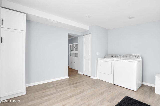 laundry area with light wood-style flooring, cabinet space, independent washer and dryer, and baseboards