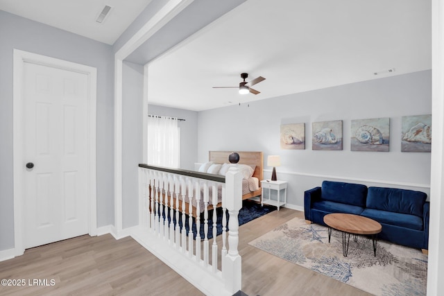 bedroom with baseboards, visible vents, and wood finished floors